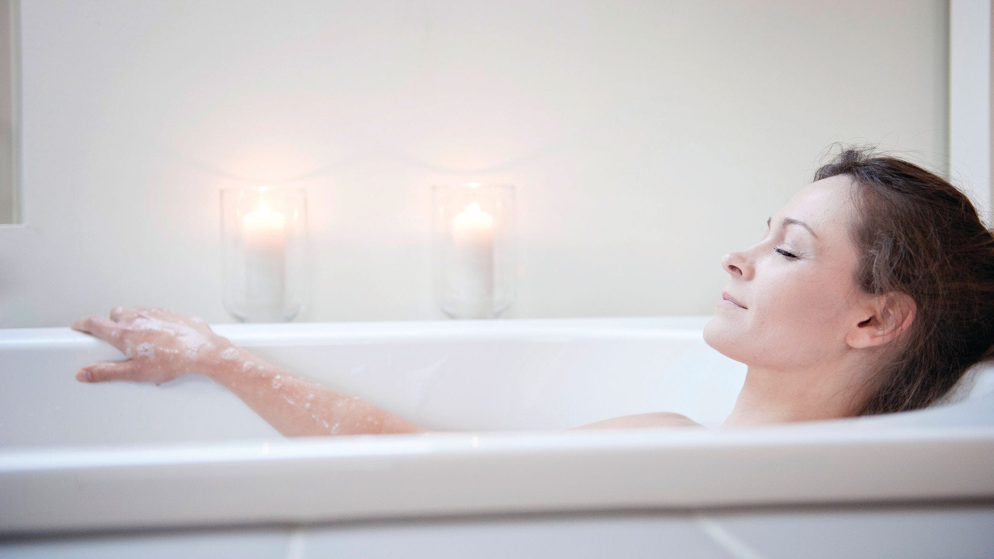 Femme se relaxant dans une baignoire contenant de l'eau chauffée avec de l'énergie renouvelable à l'aide d’un chauffe-eau thermodynamique.