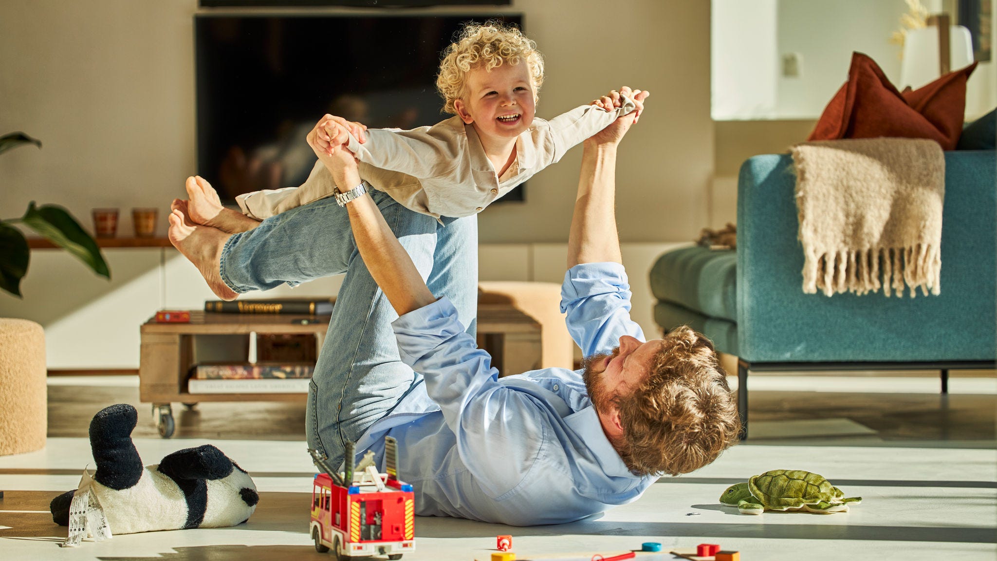 Un papa et son enfant s'amusant à jouer ensemble et profitant de la chaleur du chauffage par le sol