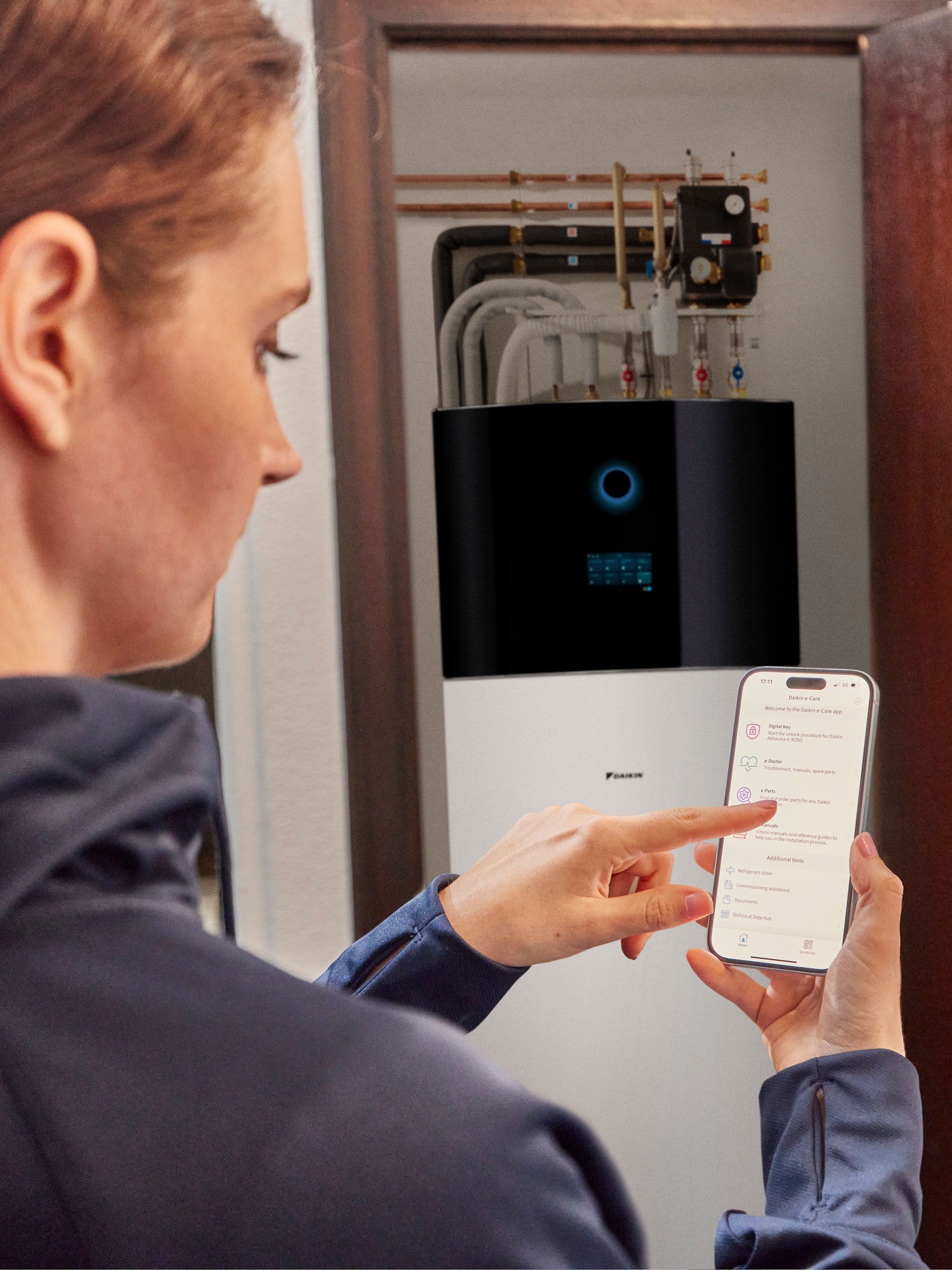 Une femme commande sa pompe à chaleur à distance via son smartphone dans une maison moderne