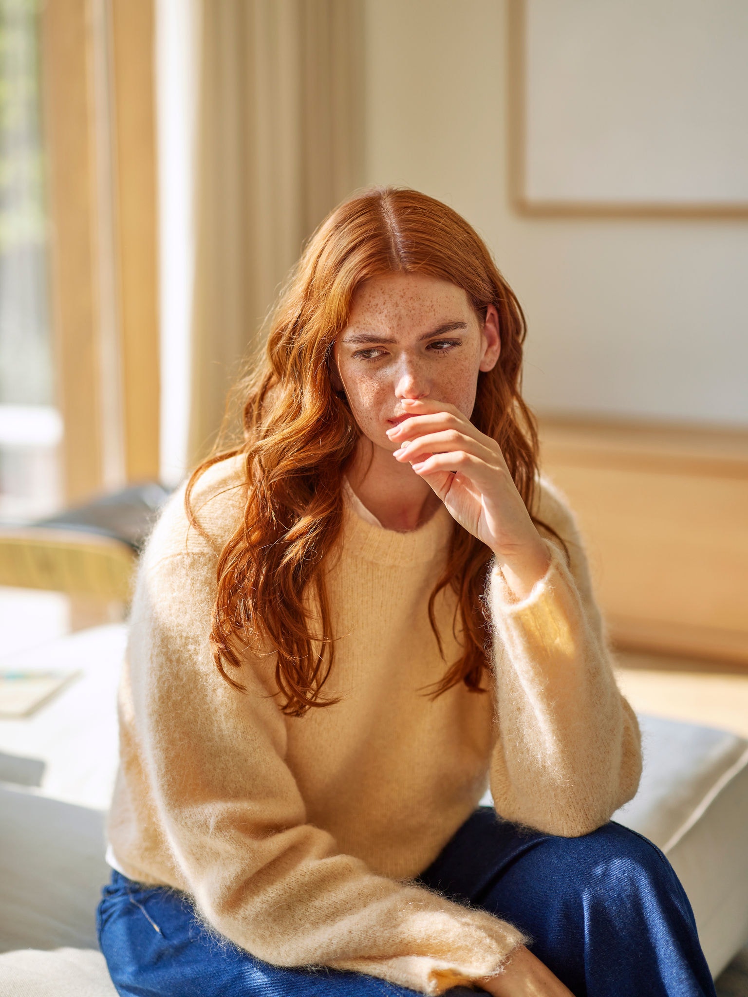 Femme réagissant à des odeurs de cuisine désagréables dans le salon