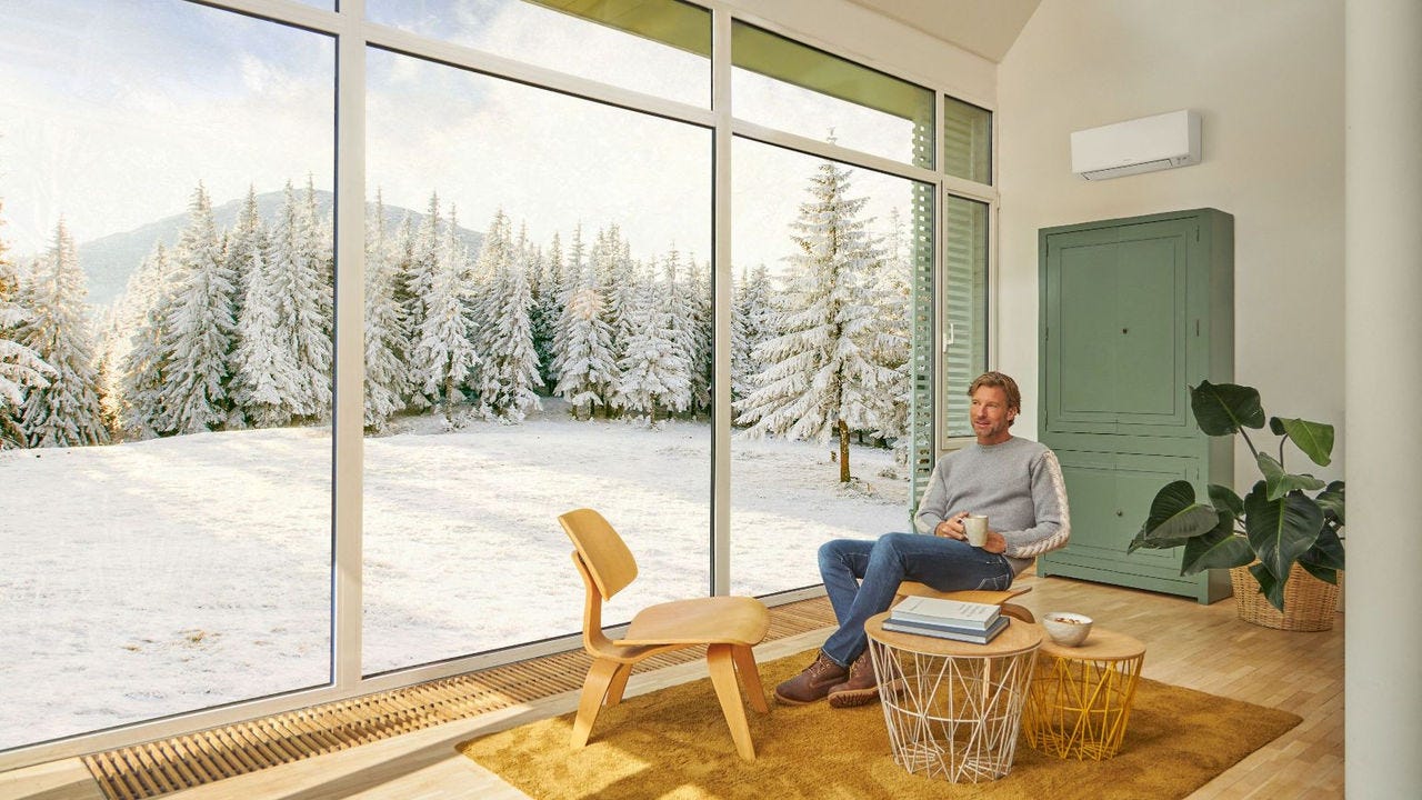 Homme assis sur un canapé, profitant de la douce chaleur générée par un système de climatisation