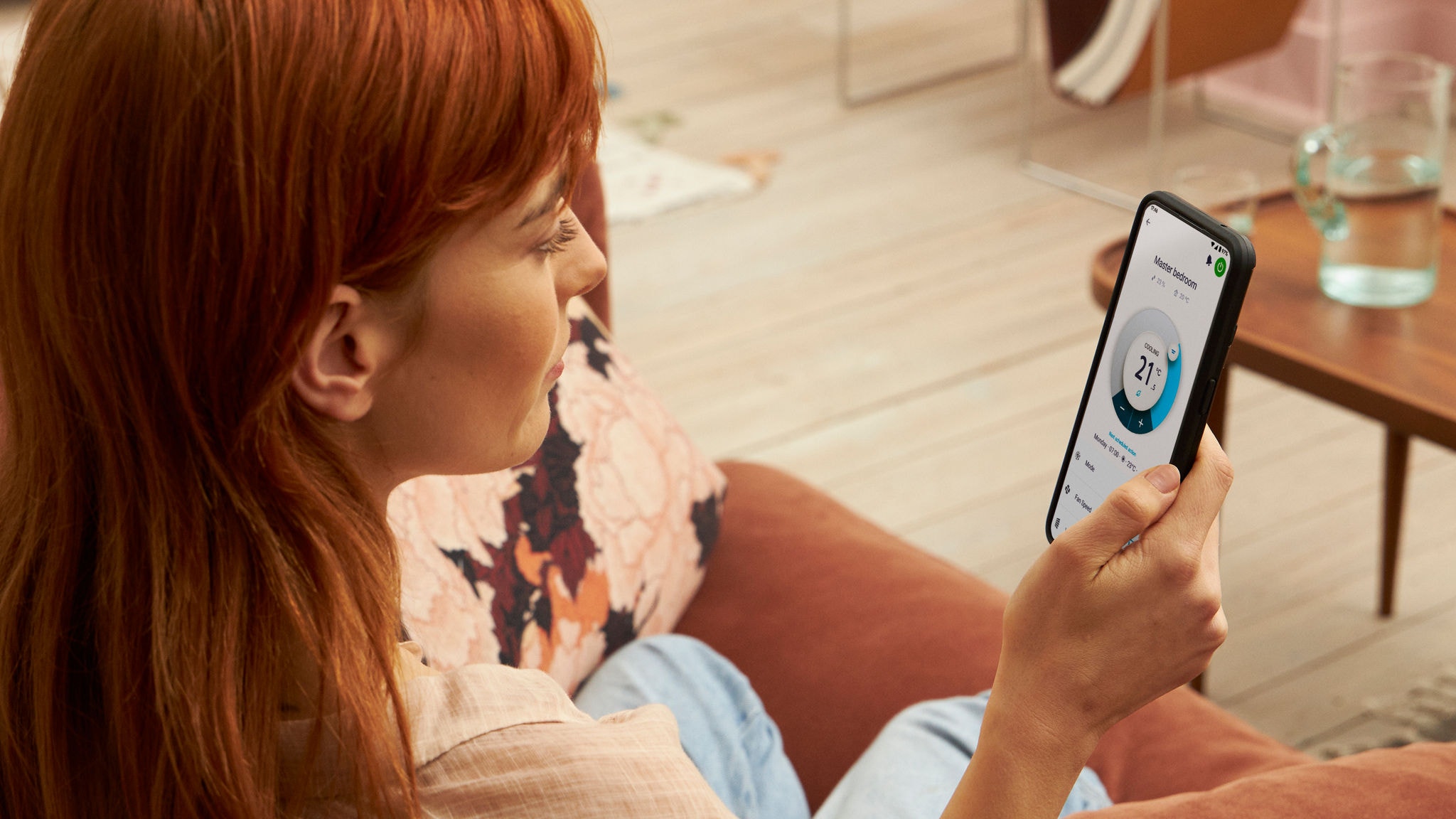 Une femme utilisant l'application Onecta pour vérifier le chauffage