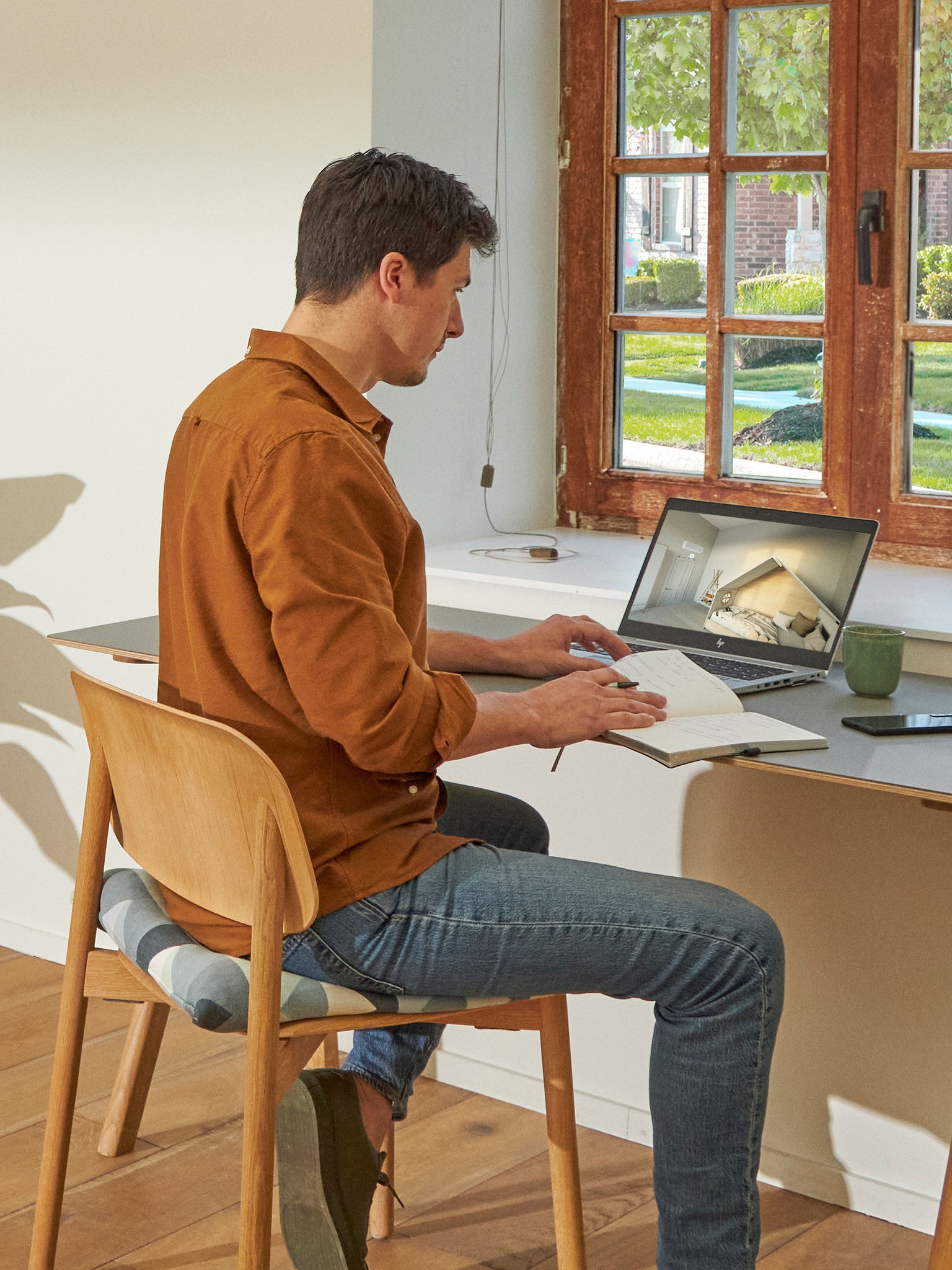 Homme assis à son bureau regardant des climatiseurs dans le showroom virtuel sur son ordinateur portable