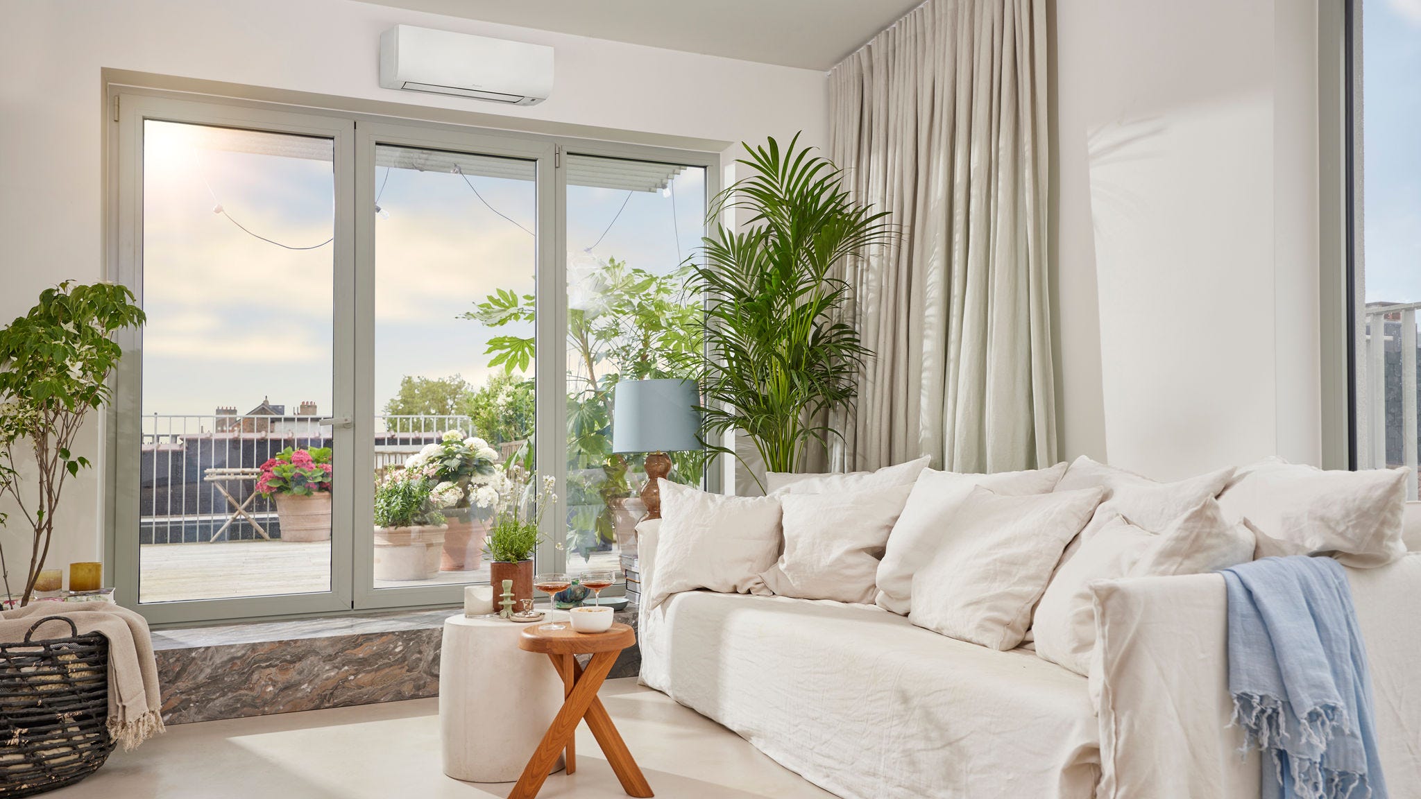 Une pièce lumineuse et aérée avec une pompe à chaleur air‑air murale blanche discrète assurant à la fois chauffage et rafraîchissement
