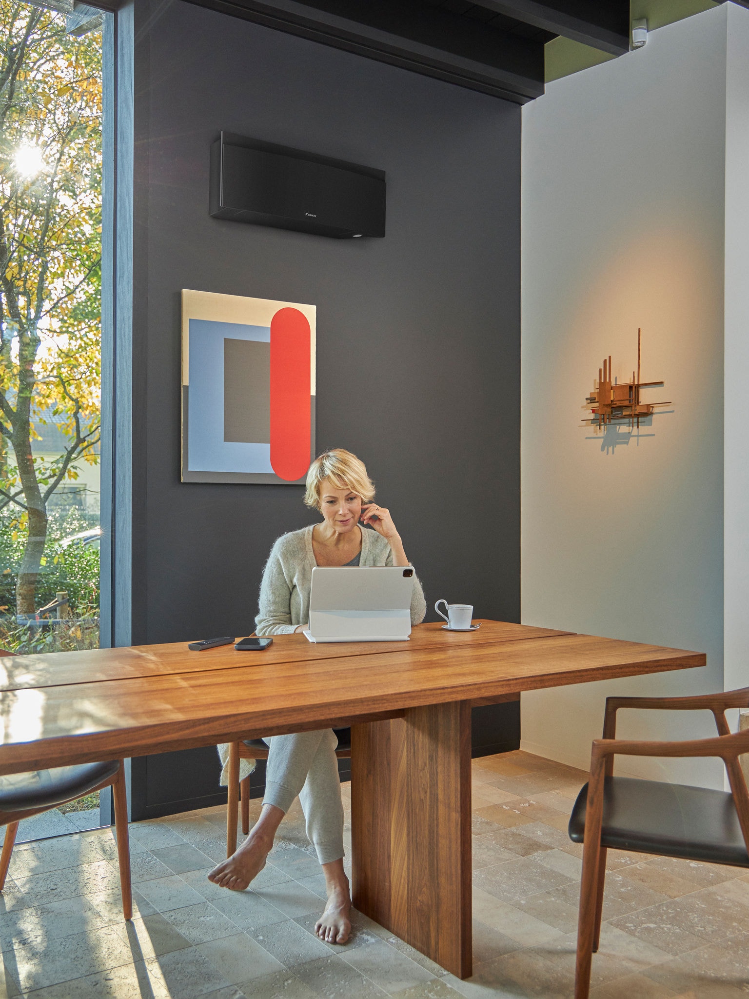 Femme utilisant une tablette dans une salle à manger avec un climatiseur mural
