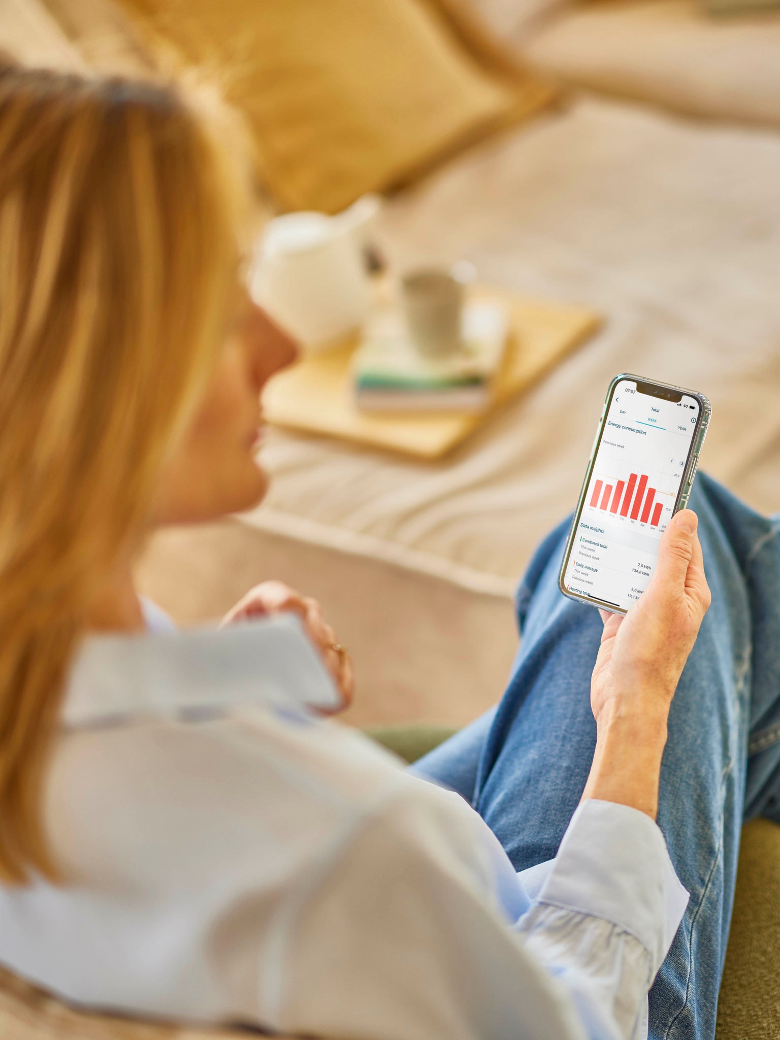 Une femme blonde consultant sa consommation d’énergie sur une application mobile