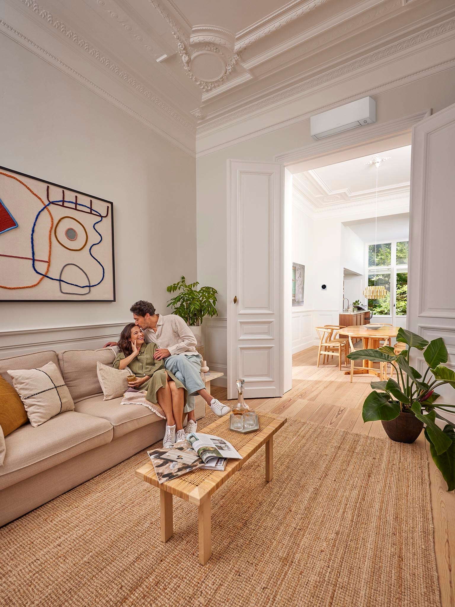 Couple se détendant à l'intérieur avec un climatiseur Inverter assurant leur confort