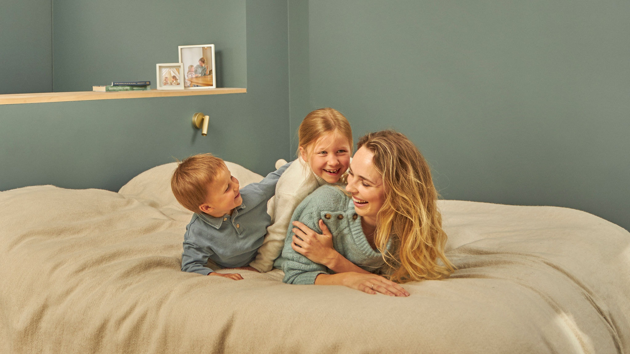 Mère jouant avec ses enfants dans leur lit