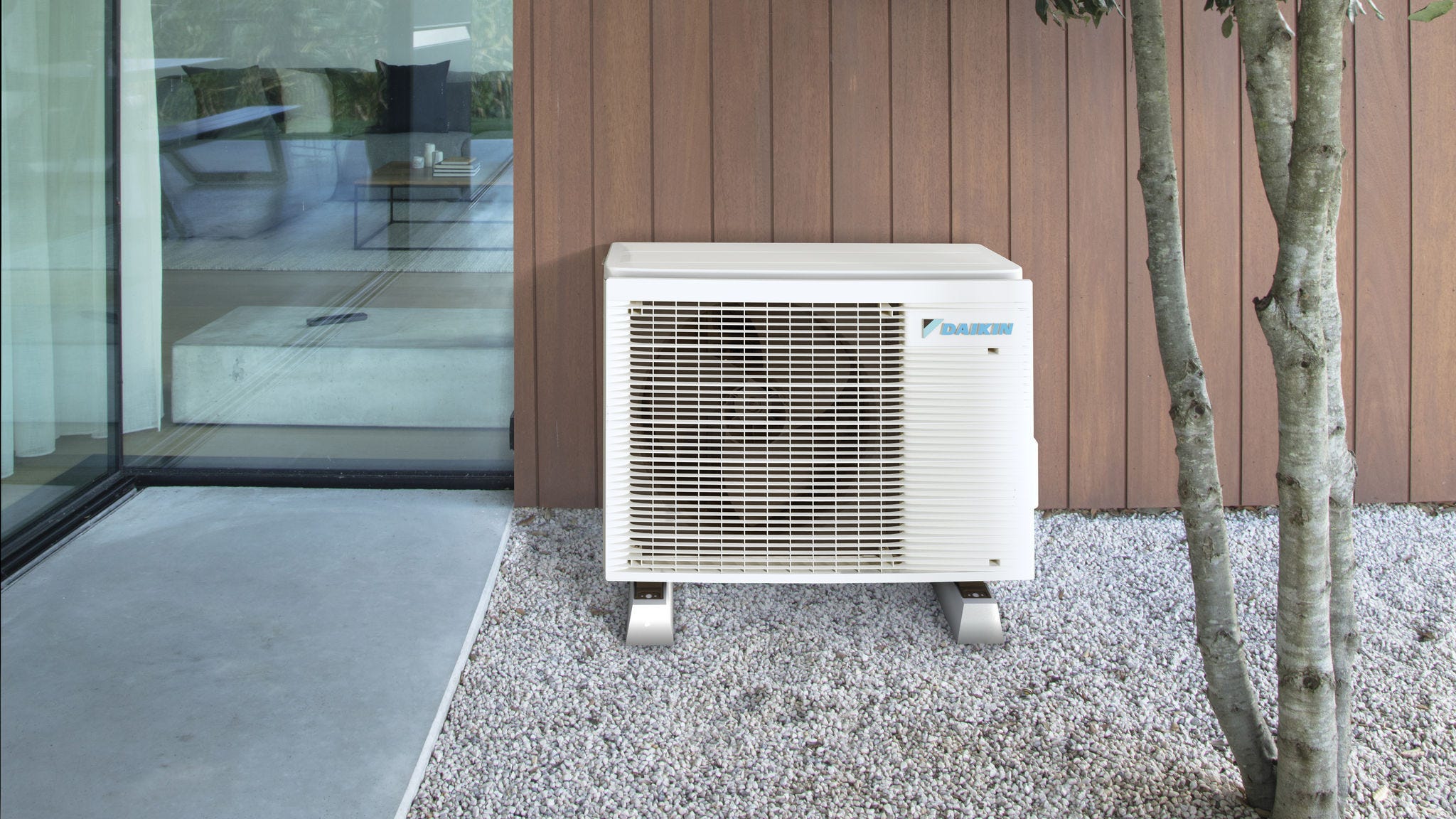 Pompe à chaleur aérothermique compacte installée discrètement à l’extérieur, à côté d’une maison moderne