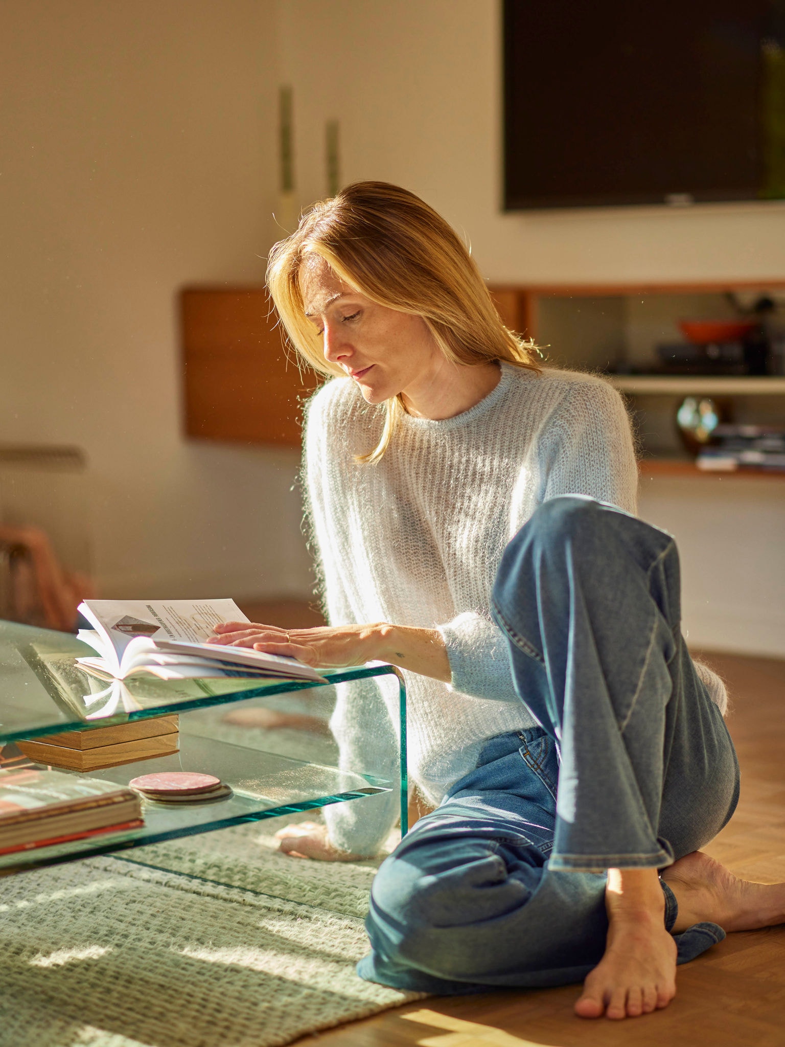 Une femme se détendant avec un livre dans une maison éco-énergétique chauffée par une pompe à chaleur