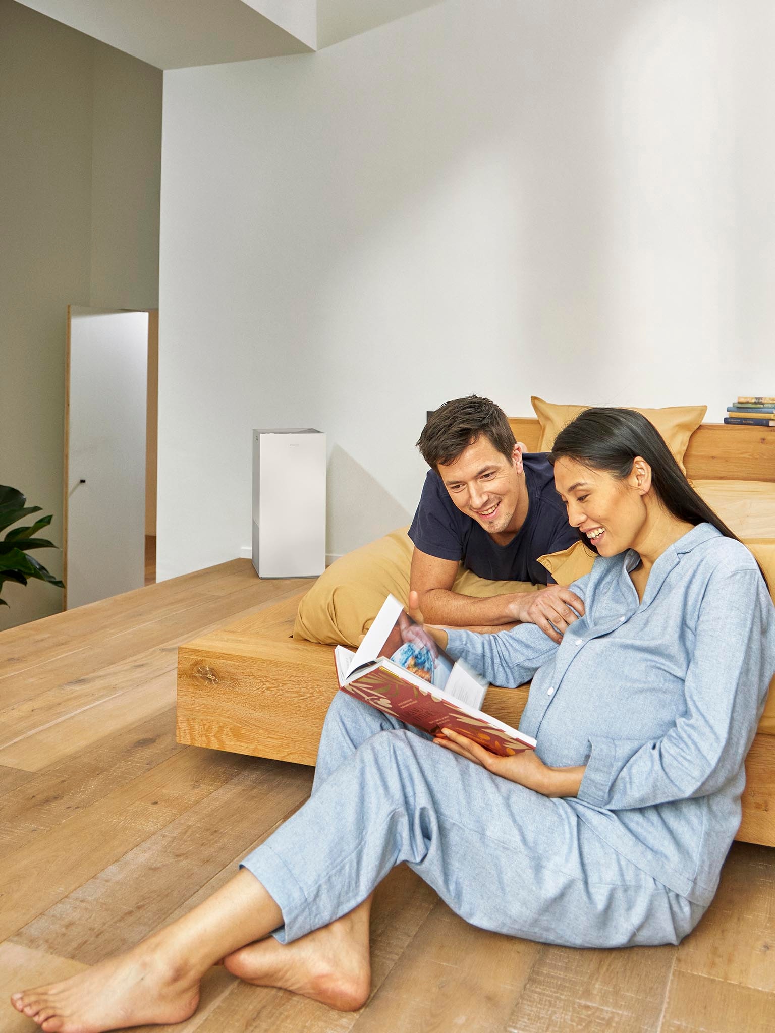 Couple se détendant dans une chambre avec un purificateur d'air améliorant la qualité de l'air intérieur