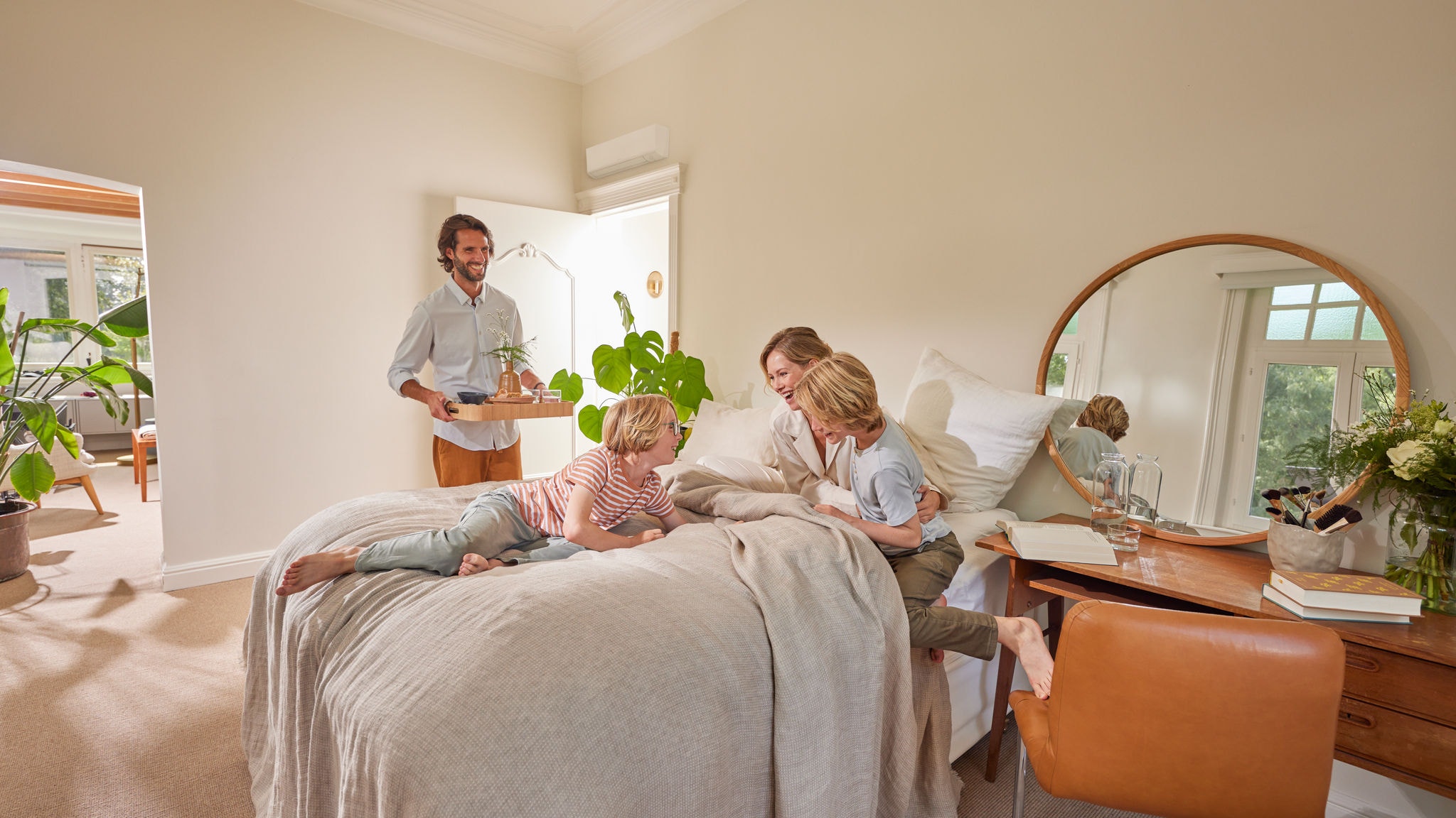 Une famille savourant un moment agréable dans une chambre avec une pompe à chaleur hybride installée sur le mur