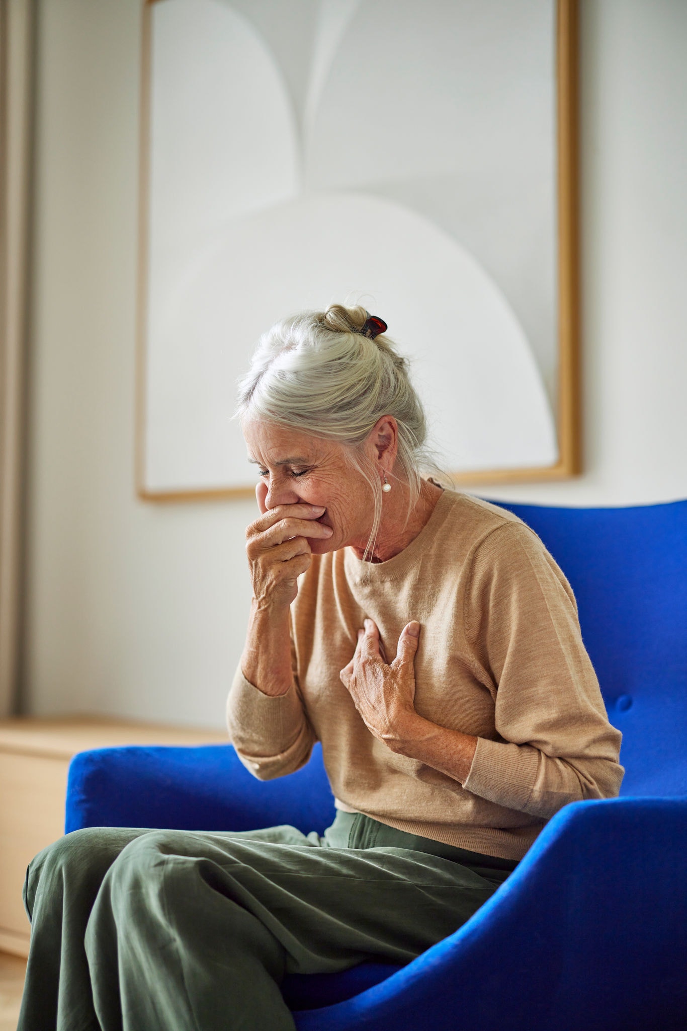 Femme qui éternue, illustrant comment la ventilation favorise une meilleure qualité de l'air et réduit les déclencheurs de l'asthme