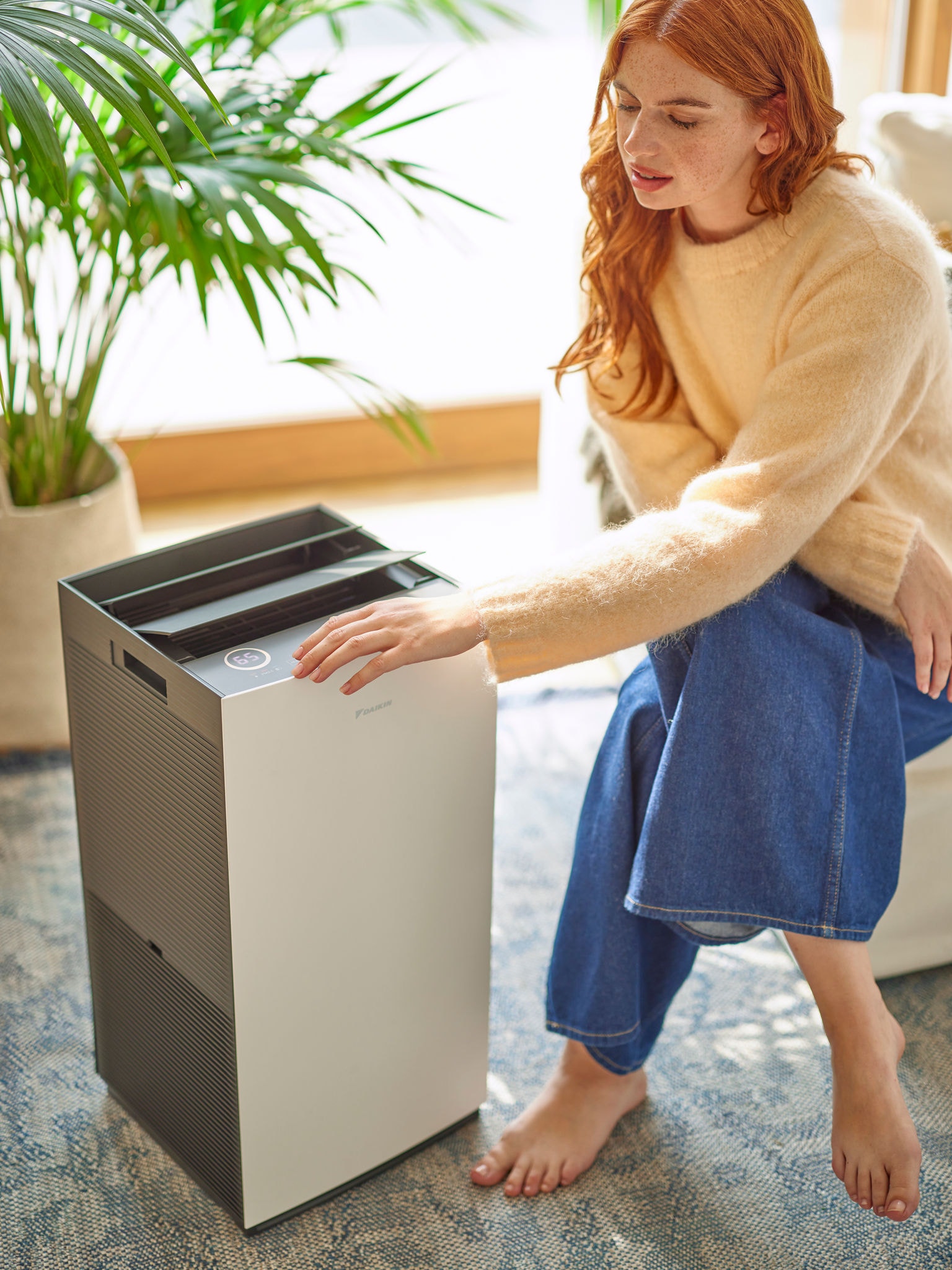 Femme ajustant les réglages d'un purificateur d'air Daikin
