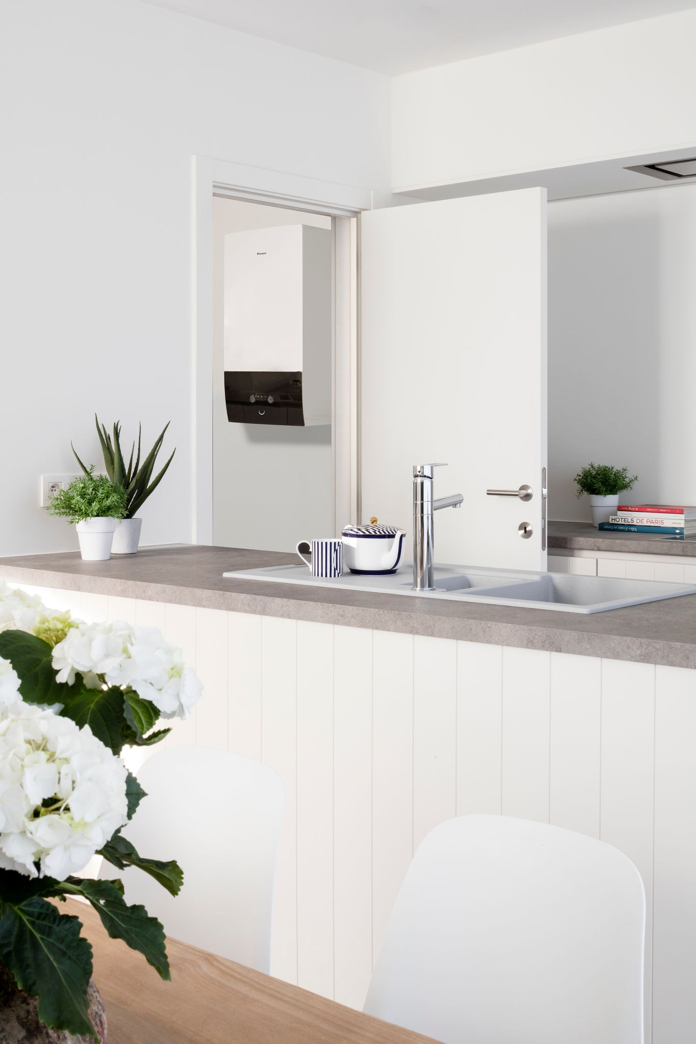 Pompe à chaleur air-eau installée à côté d’une cuisine, illustrant comment elle augmente la valeur de votre propriété