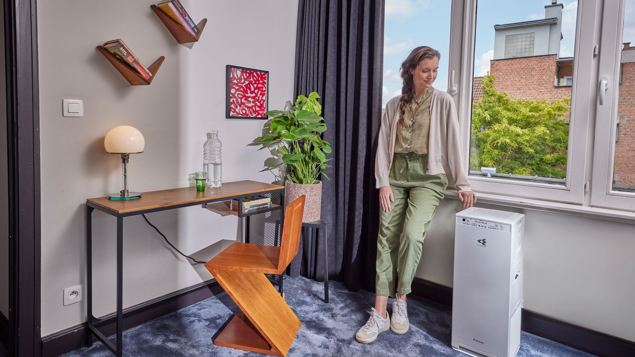 Femme activant un purificateur d'air pour améliorer la qualité de l'air intérieur et réduire les allergènes