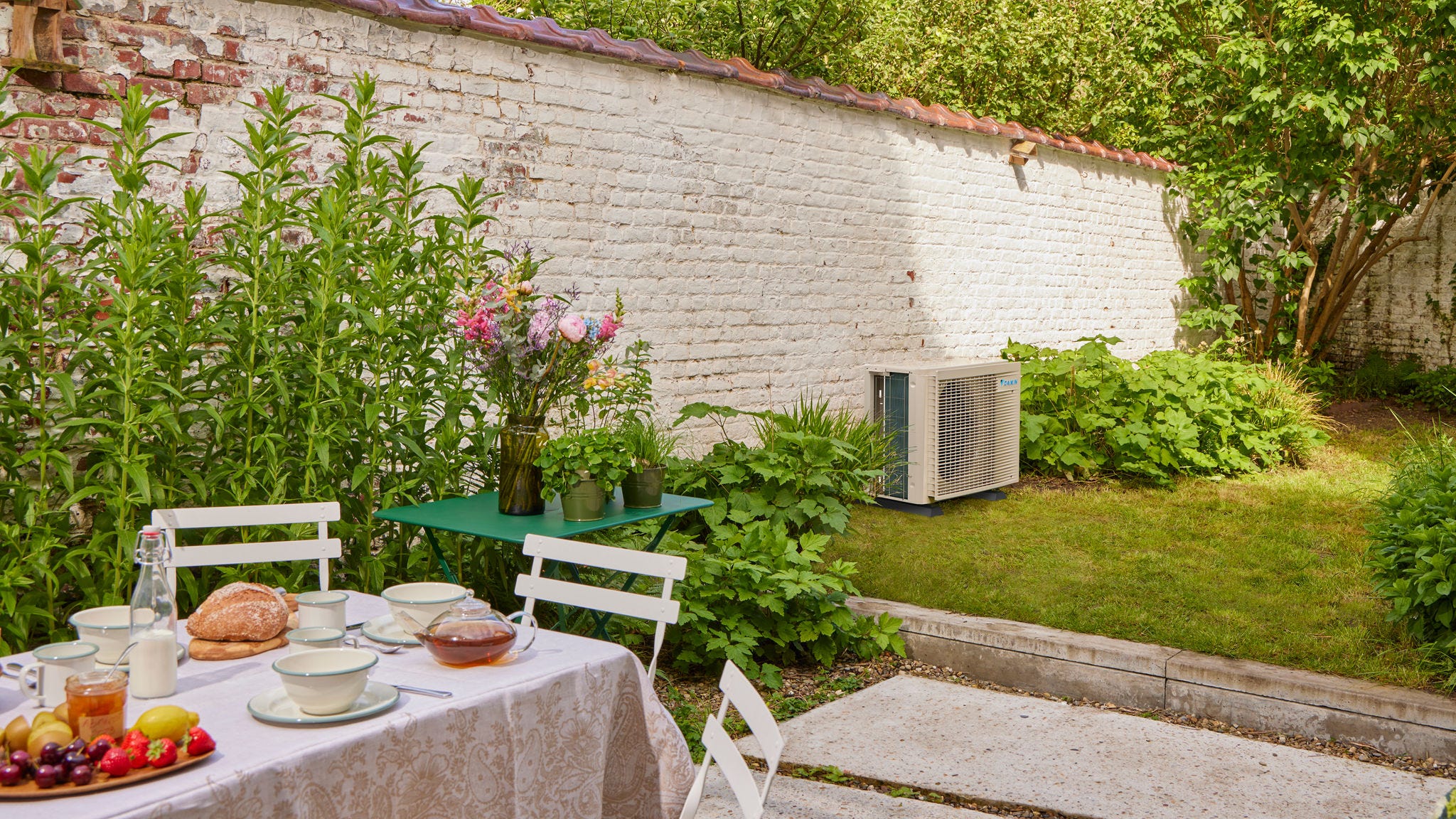 Petit-déjeuner au jardin avec un climatiseur Inverter rafraîchissant la maison à proximité