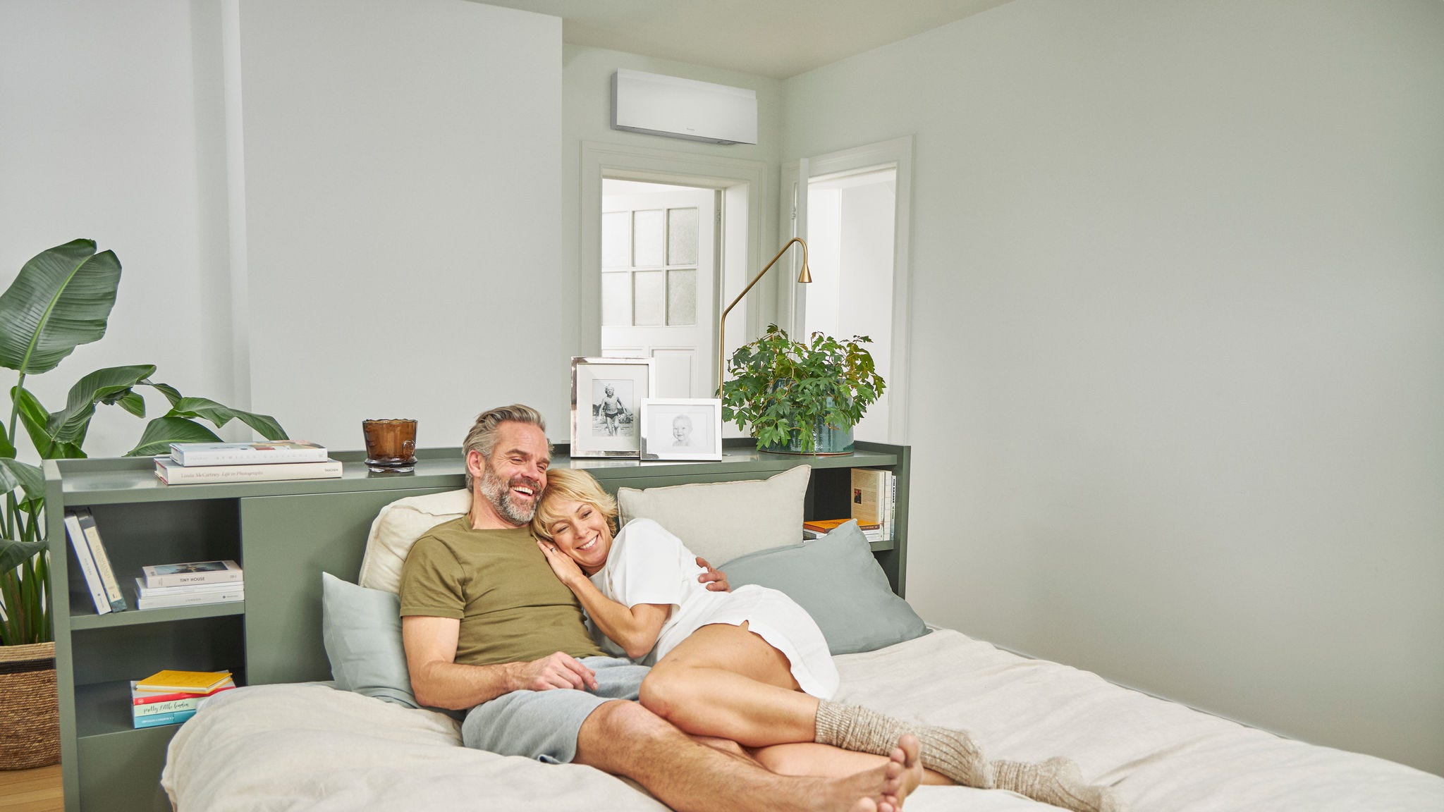 Un couple se détend sur un lit dans une chambre fraîche bénéficiant d'une climatisation silencieuse