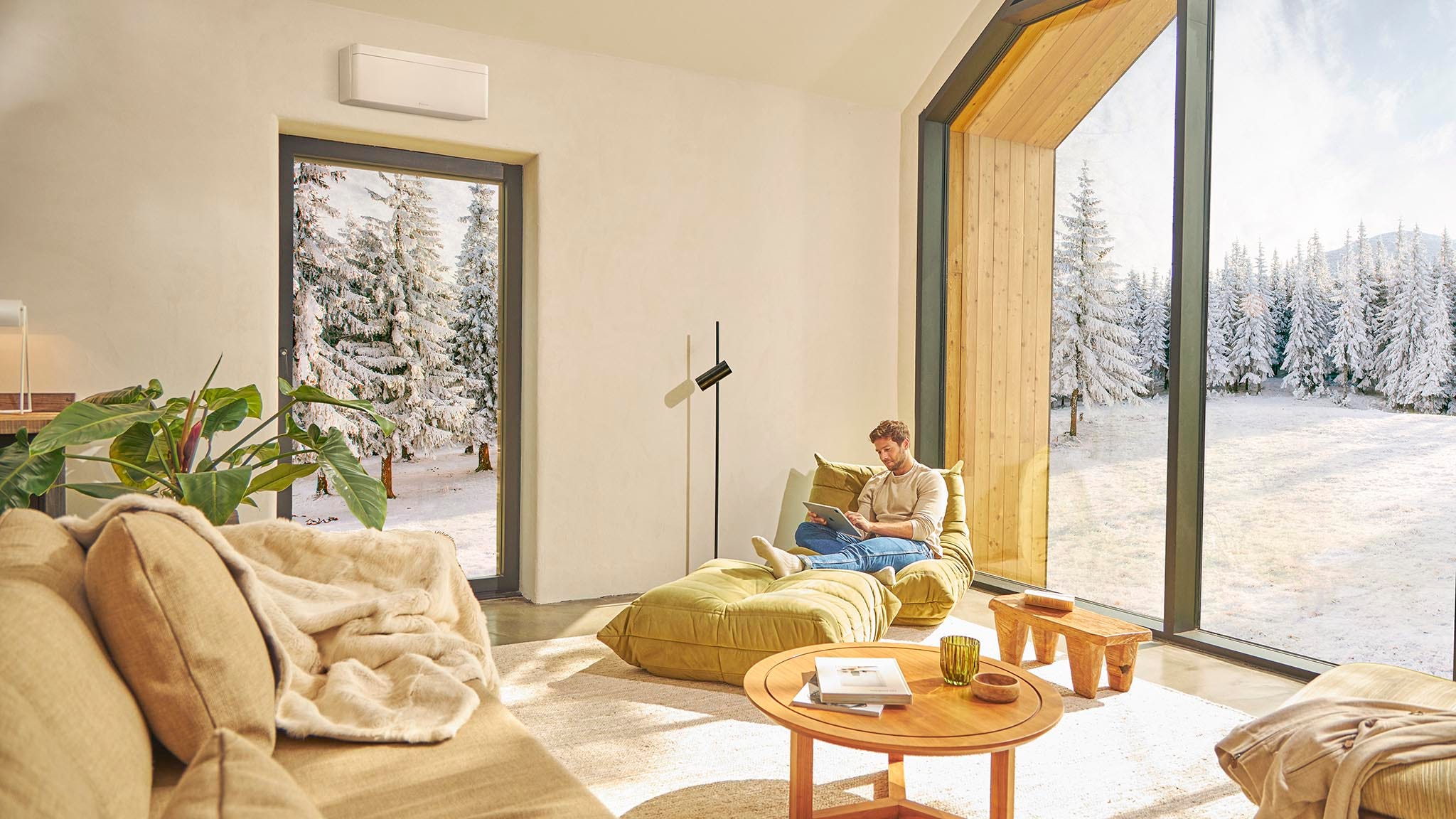 Homme assis sur un canapé, profitant de la douce chaleur générée par un système de climatisation