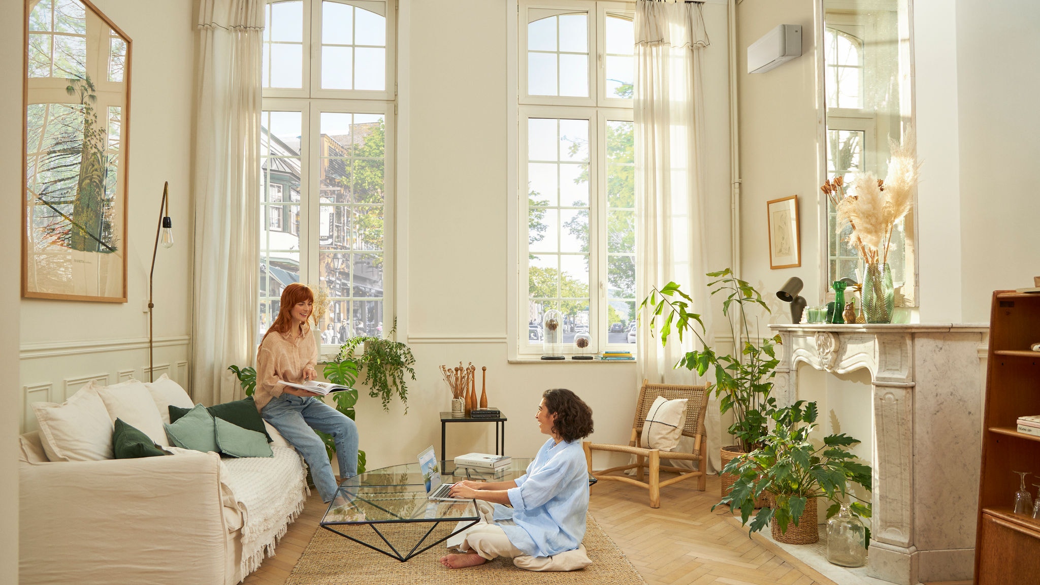 Femme assise confortablement dans le salon grâce aux pompes à chaleur air- air de Daikin