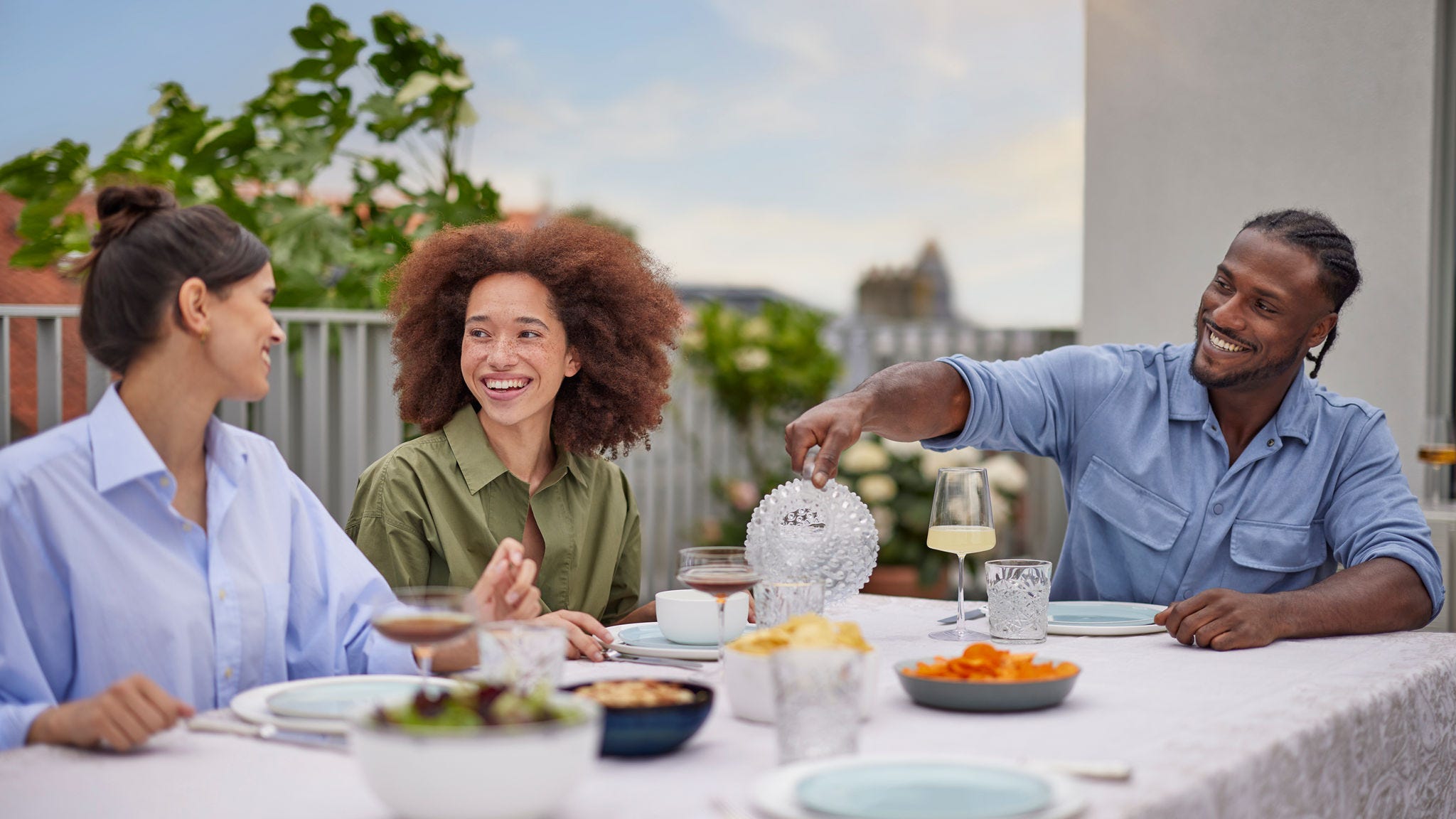 Amis dînant ensemble confortablement grâce à une pompe à chaleur aérothermique silencieuse